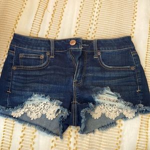 American Eagle dark blue shorts with lace detailing on the ends of pockets.